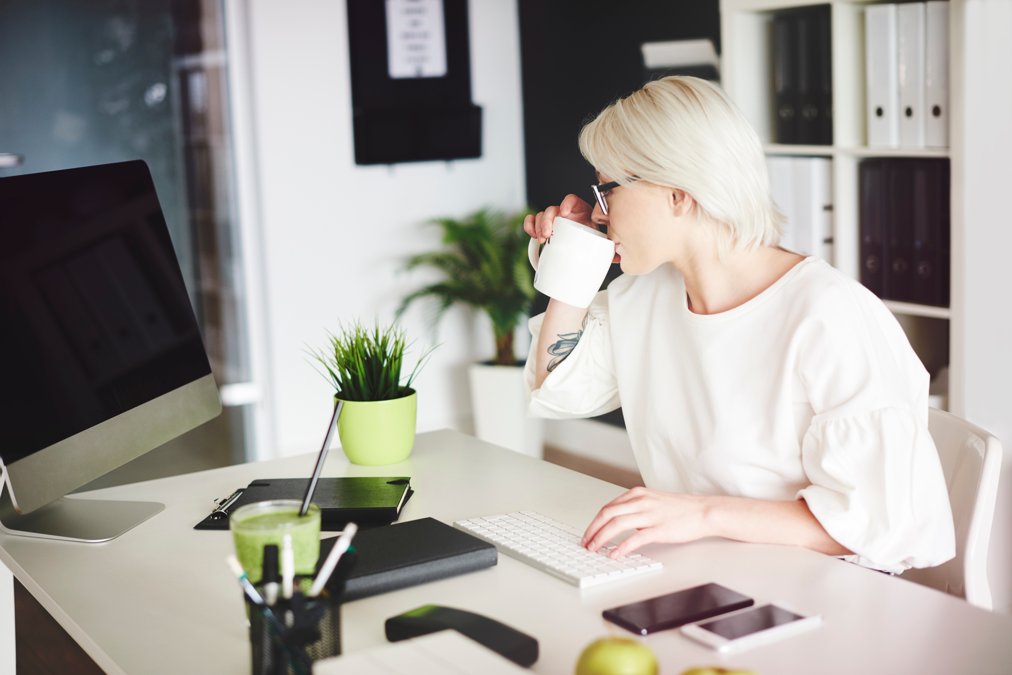 woman drinking coffee and browsing on computer